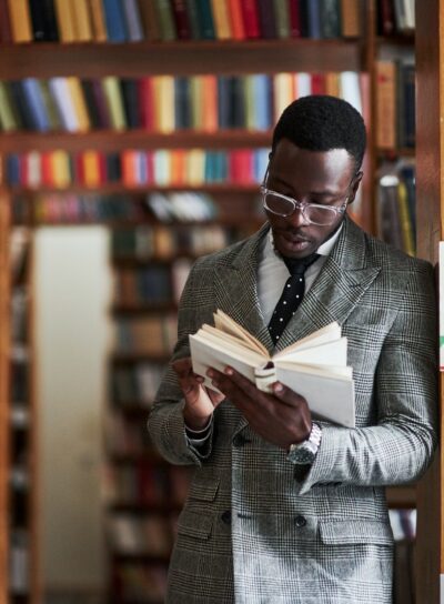 An African American man in a business suit standing in a library in the reading room